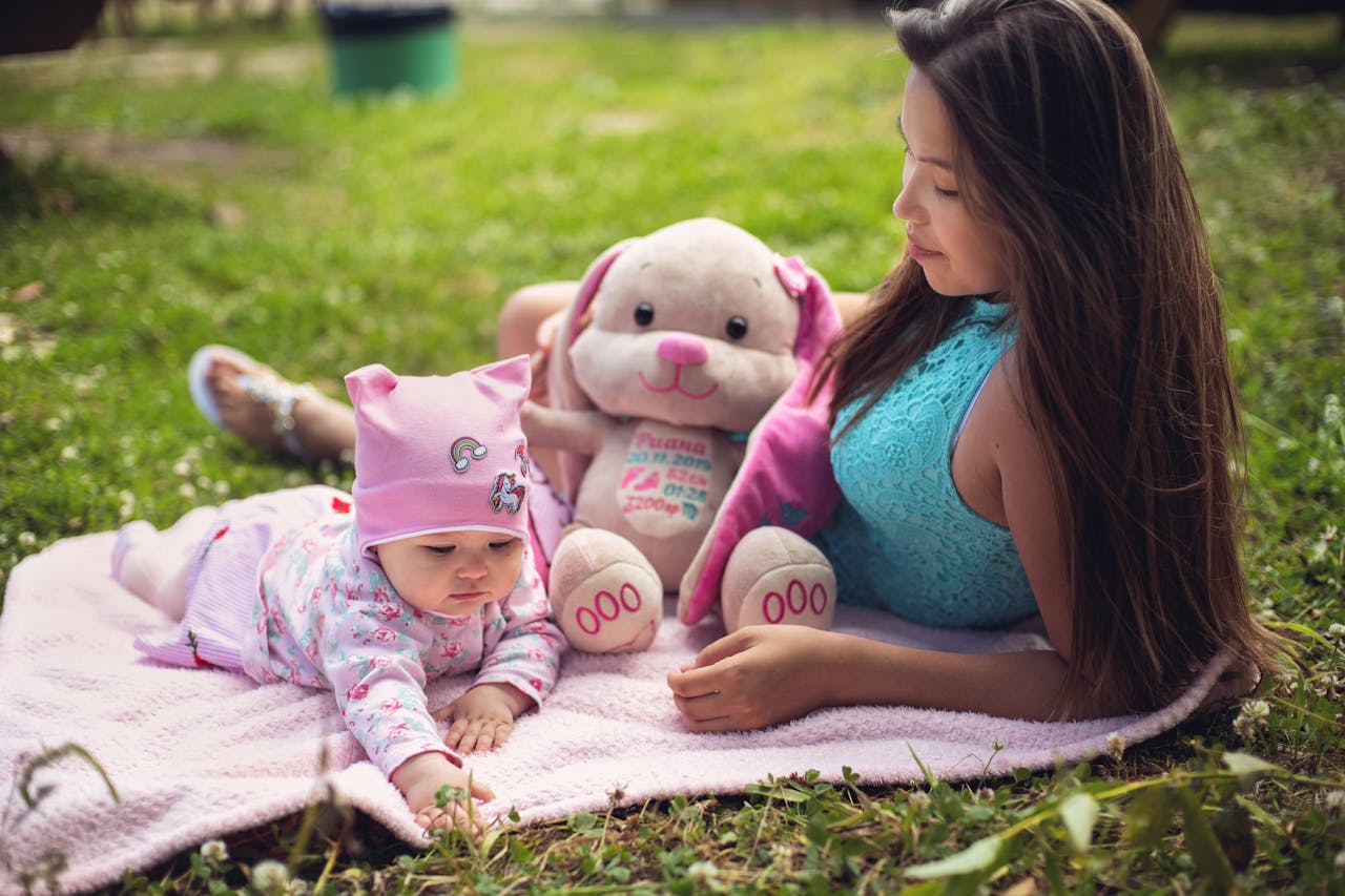Cheerful scene with a mother and baby enjoying outdoor picnic on a sunny day.